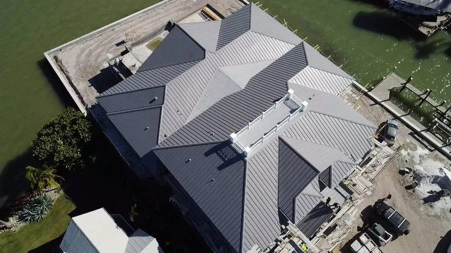 Complex hip roof standing seam metal waterfront estate Fort Myers